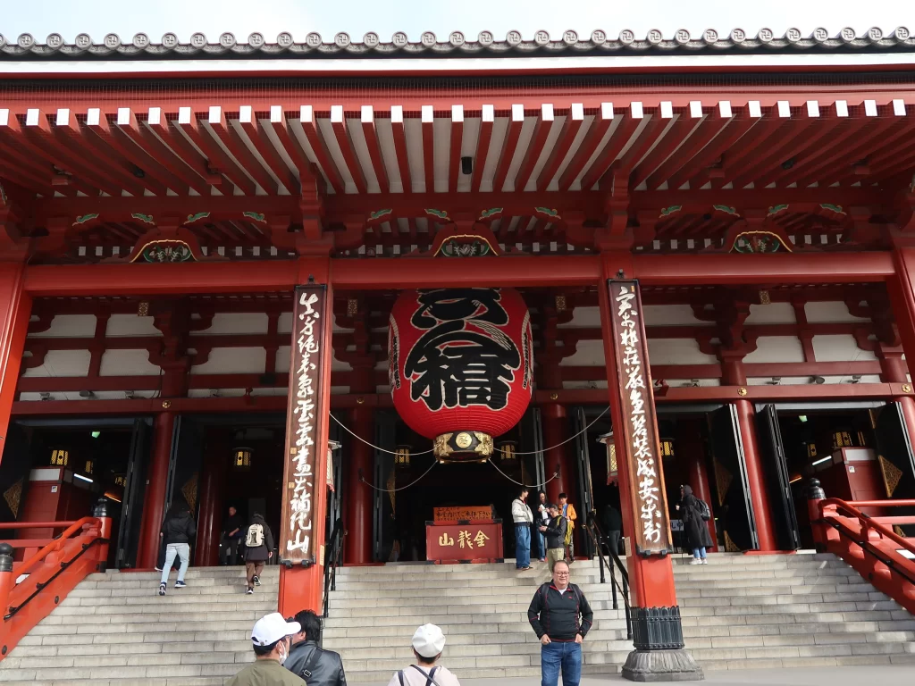 Main hall of Sensoji Temple in Asakusa Tokyo with large red lantern and visitors entering in the morning