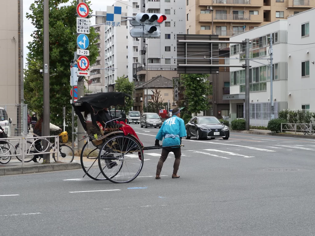 Traditional rickshaw being pulled by a guide on a street near Asakusa Tokyo with passenger seat