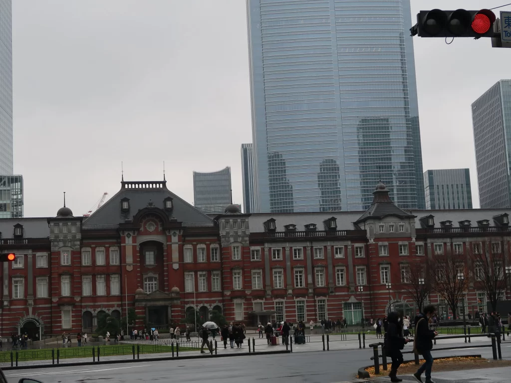 Tokyo Station on a rainy day with people walking under cloudy skies