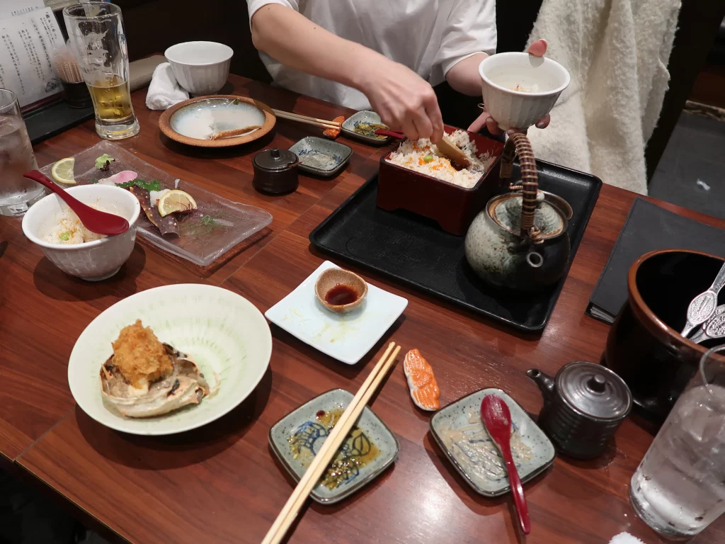 people sharing food japanese dining table