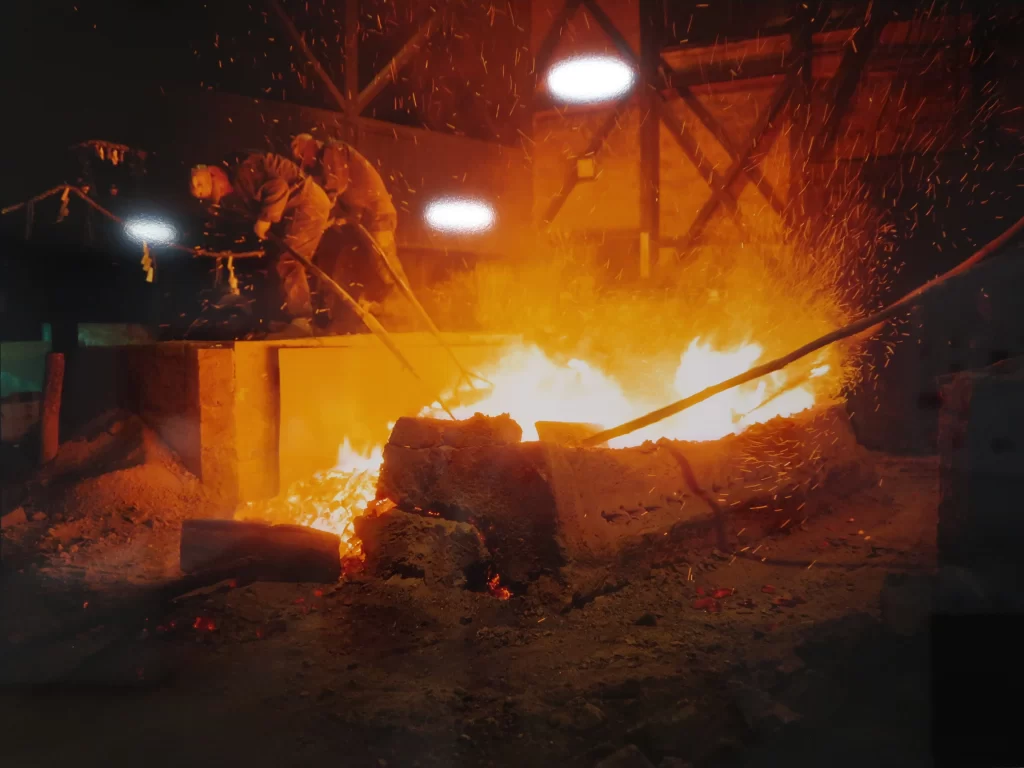 Japanese sword forging process with blacksmith heating and hammering steel in traditional workshop